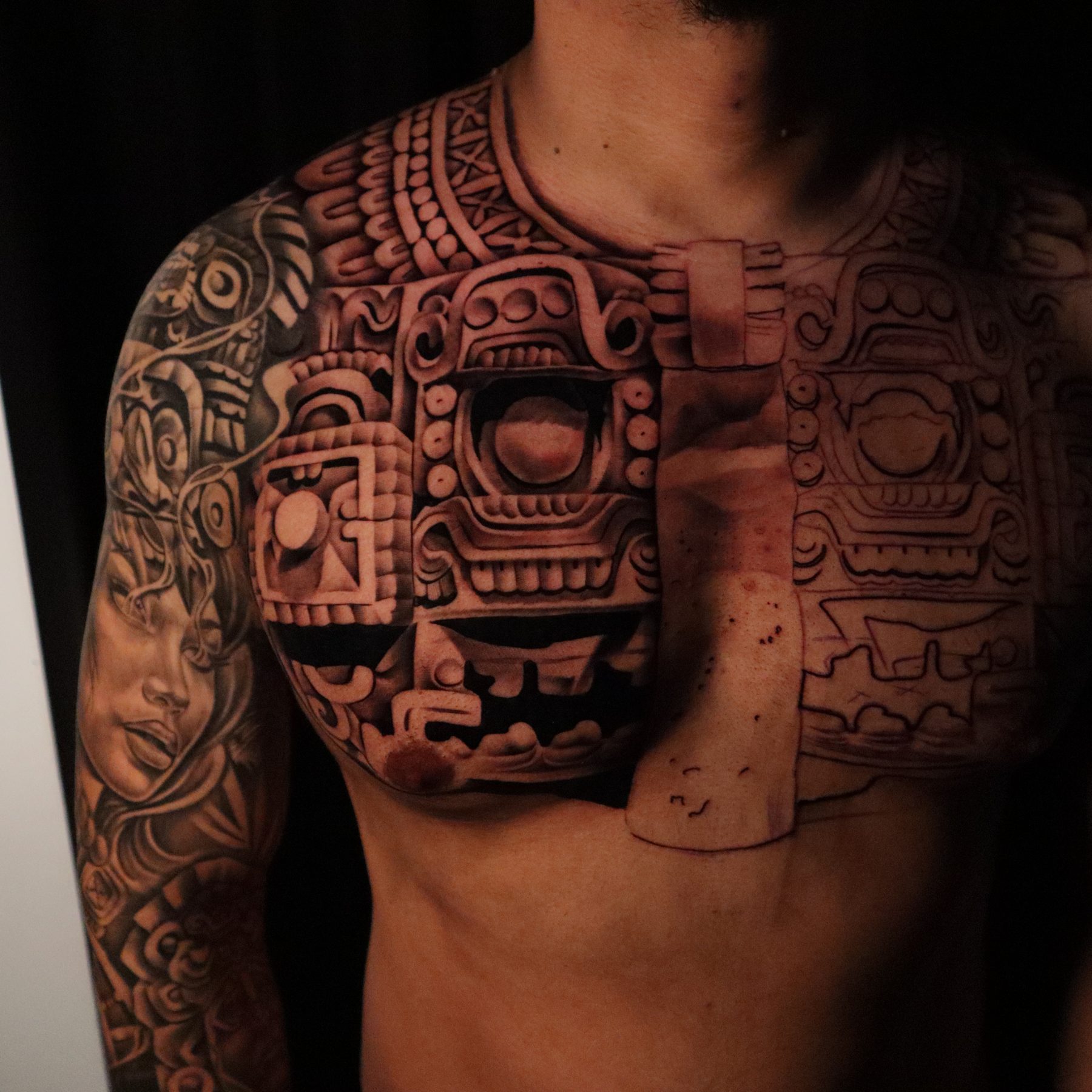 Black and grey Aztec chest piece with a sun stone and temple, tattoo by Keaks Hurtado
